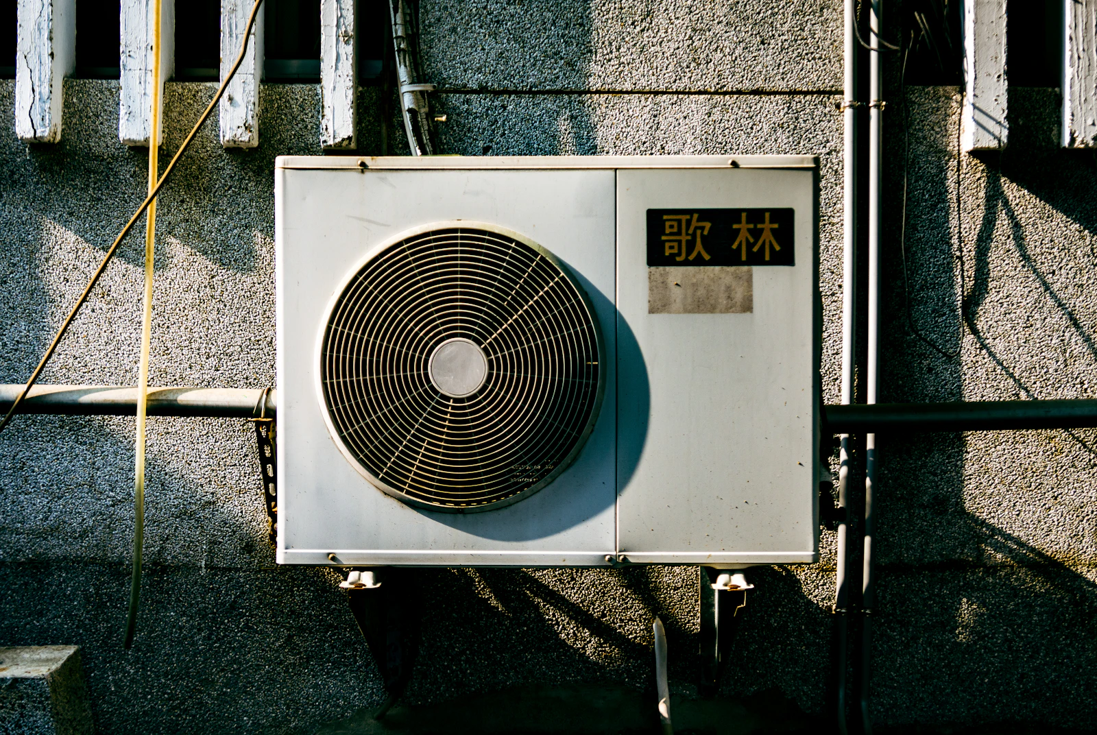Buitenunit van een airco aan de gevel van een woning