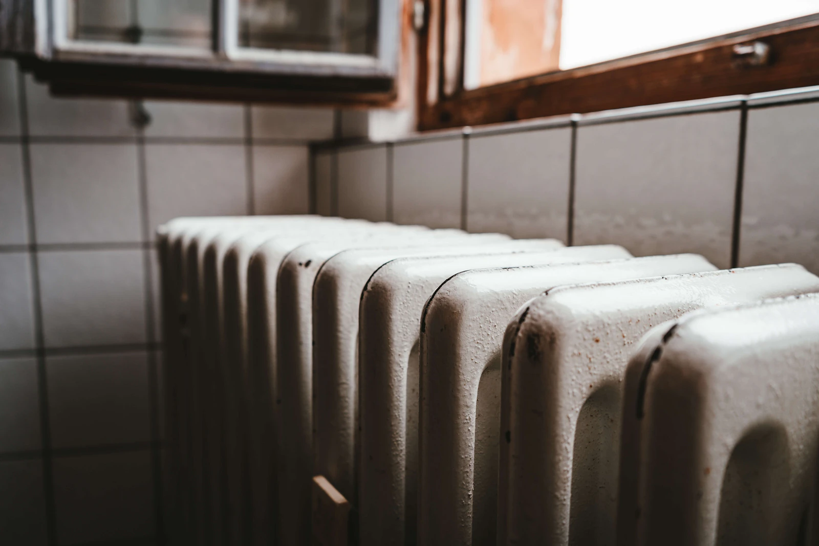 Radiator onder het raam in een woonkamer die verwarmd wordt met een warmtepomp