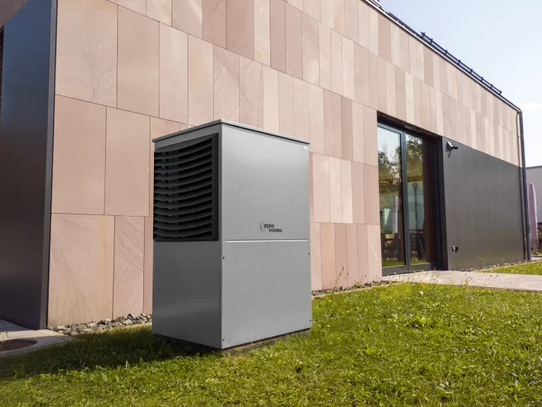 Warmtepomp buitenunit op het grind naast de gevel