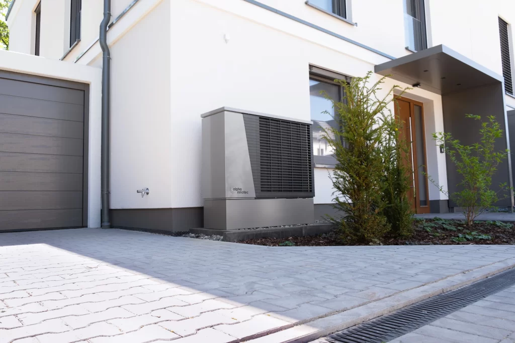 Moderne woning met een warmtepomp buitenunit naast de gevel