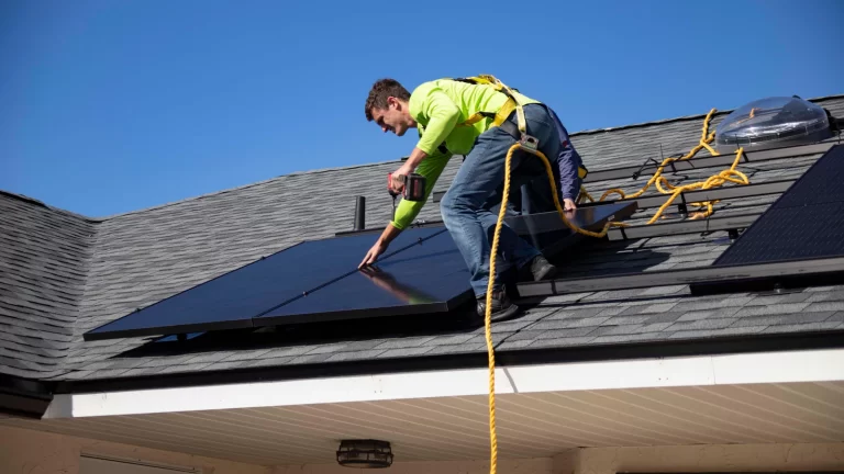 Monteur op het dak bij het plaatsen van zonnepanelen